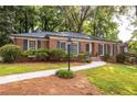Landscaped front yard with a brick facade and dark shutters for a classic look at 1342 Old Johnson Ferry Ne Rd, Brookhaven, GA 30319