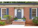 Close-up of the home's entrance, showcasing the stylish door, brickwork, and landscaping at 1342 Old Johnson Ferry Ne Rd, Brookhaven, GA 30319
