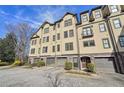 Townhome exterior featuring multiple stories, individual garages, manicured landscaping, and a brick driveway at 255 Southerland Ne Ter # 207, Atlanta, GA 30307
