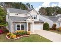 Beautiful two-story home with stone details, a gray roof, and a green lawn with flowerbeds at 245 Weatherstone Pointe Dr, Woodstock, GA 30188
