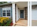 Inviting front porch with stone accents, white columns, and a welcoming wreath on the front door at 245 Weatherstone Pointe Dr, Woodstock, GA 30188