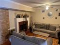 Cozy living room featuring a brick fireplace, wood floors, neutral walls, and ceiling fan at 8564 Jamestown Way, Jonesboro, GA 30238