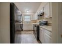 Functional kitchen featuring white cabinets and modern black appliances at 1060 Heatherwood Ct, Norcross, GA 30093