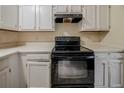 Close-up of kitchen with white cabinets and black appliances at 1060 Heatherwood Ct, Norcross, GA 30093