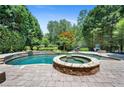 Inviting backyard pool and spa surrounded by lush landscaping, perfect for outdoor relaxation at 307 Heritage Overlook, Woodstock, GA 30188