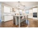 Modern kitchen features white cabinets, stainless steel appliances, and an island with seating at 1878 Weston Ln, Tucker, GA 30084