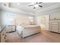 Spacious main bedroom with tray ceiling, carpet, and ensuite bathroom with garden tub at 1878 Weston Ln, Tucker, GA 30084