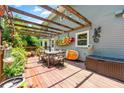 Outdoor patio with wood pergola, dining set, surfboard decoration, and lush plants at 5018 Old Ivy Rd, Peachtree Corners, GA 30096