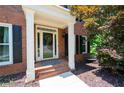 Charming front porch with brick steps and white columns, perfect for relaxing at 672 Red Sunset Cir, Powder Springs, GA 30127