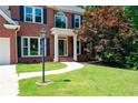 Well-manicured front yard with lush green lawn and a curved walkway leading to the entrance at 672 Red Sunset Cir, Powder Springs, GA 30127