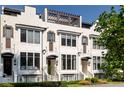 Classic white townhome featuring black framed windows, entry awnings, and manicured landscaping at 144 Northern Ave, Decatur, GA 30030