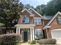 Charming red brick two-story home featuring a well-manicured front yard and inviting front porch at 1038 Island View Ct, Buford, GA 30518