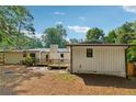 Back of the home featuring a wooden deck, patio, and a large backyard with mature trees at 5360 Fieldgreen Dr, Stone Mountain, GA 30088