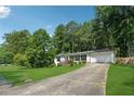 Expansive front yard view of a well-maintained home with lush landscaping and a long driveway at 5360 Fieldgreen Dr, Stone Mountain, GA 30088