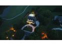 Aerial view of a home and landscaped backyard at dusk with string lights over the outdoor living and pool area at 6325 Haddington Ln, Suwanee, GA 30024