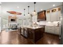 An open kitchen features a large central island, modern appliances, wood floors, and eat in dining area at 6325 Haddington Ln, Suwanee, GA 30024