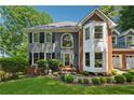 Charming two-story home boasts mature landscaping, grey siding, and a two-car garage at 1518 Maplewood Ct, Woodstock, GA 30189