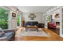 A cozy living room with hardwood floors, large windows, and decorative chandelier at 1518 Maplewood Ct, Woodstock, GA 30189