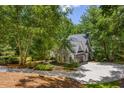 Beautiful home with mature trees, a circular driveway, and lush landscaping at 410 Waterridge Ct, Sandy Springs, GA 30350