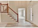 Bright foyer with hardwood floors, staircase and open doorway to the living area at 430 Tara Oaks Ct, Lawrenceville, GA 30043