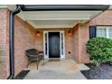 Inviting front porch with black front door, brick facade, and a cozy seating area at 430 Tara Oaks Ct, Lawrenceville, GA 30043