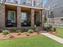 Inviting front porch with rocking chairs, brick columns, and a well-maintained garden at 630 Brashy St, Woodstock, GA 30188