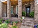 Inviting front porch with rocking chairs, brick columns, and a well-maintained garden at 630 Brashy St, Woodstock, GA 30188