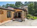 Welcoming front entrance featuring stone accents, a black front door, and beautifully landscaped surroundings at 1024 Lake Charles Dr, Roswell, GA 30075