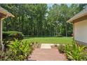 Manicured backyard with brick pathway invites peaceful relaxation amidst lush greenery and trees at 105 Postwood Dr, Fayetteville, GA 30215