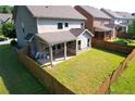 Aerial view of a fenced backyard with a covered patio and ample green space at 2600 Arnold Palmer Way, Duluth, GA 30096