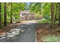 Traditional two story home with brown stucco and stone exterior with a long driveway at 5455 Malone Ct, Powder Springs, GA 30127