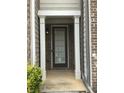 Inviting covered front porch with white columns and brick siding at 5671 Radford Loop, Fairburn, GA 30213