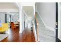 Inviting foyer featuring hardwood floors, staircase, and views into the dining room, creating an elegant entrance at 3869 Maiden Fern Ln, Snellville, GA 30039