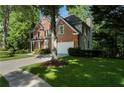 Brick home with a well-maintained lawn, mature trees, and a convenient two-car garage at 1575 Wynridge Pointe, Alpharetta, GA 30005
