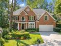 Attractive brick home with lush landscaping, a well-kept lawn, and a two-car garage at 1575 Wynridge Pointe, Alpharetta, GA 30005