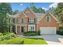 Beautiful brick home featuring manicured landscaping, healthy green grass, and a two-car garage at 1575 Wynridge Pointe, Alpharetta, GA 30005