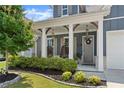 Inviting front porch featuring hanging chairs, stylish lighting, and well-maintained landscaping at 876 Samples Nw Ln, Atlanta, GA 30318