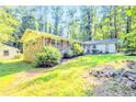 A ranch-style house with a brick facade, complemented by lush lawn and mature shrubbery, offering great curb appeal at 1445 Woodhill Dr, Marietta, GA 30066