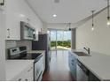 A modern kitchen with stainless steel appliances, white cabinets, and great views from the connected living space at 361 17Th St # 910, Atlanta, GA 30363