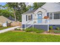 Inviting brick home featuring a charming blue front door and a lush, landscaped yard, enhancing curb appeal at 512 Allendale Dr, Decatur, GA 30032