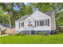 Angle shot of a delightful brick home with a vibrant lawn and a welcoming front porch with blue trim at 512 Allendale Dr, Decatur, GA 30032