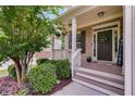 Inviting front porch with brick accents, tasteful decor, and lush, manicured landscaping at 5473 Heatherbrooke Nw Dr, Acworth, GA 30101