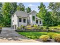 Well-manicured lawn featuring a modern home design with a three car garage and black frame windows at 6070 Lively Ct, Cumming, GA 30040