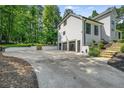 View of a modern three car garage and concrete driveway at 6070 Lively Ct, Cumming, GA 30040
