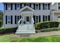 Inviting front entrance with white stairs, dark shutters, and neat landscaping, enhancing curb appeal at 939 Flowers Xing, Lawrenceville, GA 30044