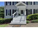 Inviting front porch with white railing and stairs leading to the front door, framed by manicured landscaping at 939 Flowers Xing, Lawrenceville, GA 30044