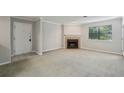 Cozy living room featuring a fireplace with brick accents, a window, and a neutral color palette at 511 Barrington Hills Dr, Atlanta, GA 30350