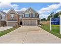 View of a two-story townhome with two-car garage near a sales center at 1311 Park Center Cir, Austell, GA 30168