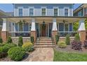 Inviting front porch with cozy seating, brick pillars, and decorative plants enhancing curb appeal at 4256 Weaver Se St, Smyrna, GA 30080