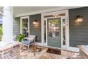 Welcoming front porch with stone flooring, comfortable seating, and a stylish entrance door at 1622 Gates Nw Pl, Atlanta, GA 30318